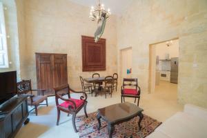 a living room with a table and chairs and a chandelier at HT1- Heritage Treasure 1 in Valletta
