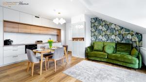 a living room with a green couch and a table at Wonder Home - Apartamenty blisko centrum, tuż przy kolei gondolowej i trasach Single Track in Świeradów-Zdrój
