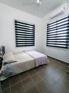 1 Schlafzimmer mit einem Bett und 2 Fenster mit Jalousien in der Unterkunft Homestay Kemaman Fyna02 di Bukit Kuang in Kampong Kemaman