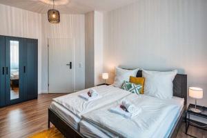 a bedroom with a large white bed with two towels on it at cozy Apartment -Traminer- mit MagentaPlus in Meißen