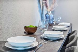 a table with plates and bowls and a wine glass at cozy Apartment -Traminer- mit MagentaPlus in Meißen +2 photos