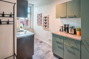 a kitchen with blue cabinets and a counter top at cozy Apartment -Traminer- mit MagentaPlus in Meißen