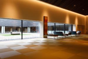 a lobby of a building with chairs and windows at Tokachigawa Moor Onsen Seijyakubow in Otofuke