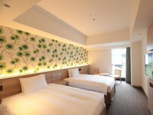 a hotel room with two beds and a wall mural at TOKYO EAST SIDE HOTEL KAIE in Tokyo