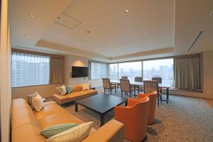 a living room with orange furniture and a dining room at TOKYO EAST SIDE HOTEL KAIE in Tokyo