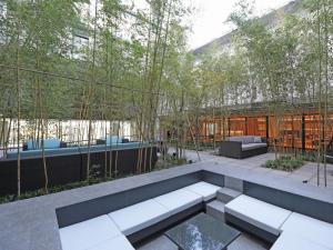 un jardín con un banco frente a un edificio en TOKYO EAST SIDE HOTEL KAIE en Tokio