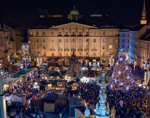 a christmas market in front of a building with a christmas tree at Grandezza Hotel Luxury Palace in Brno