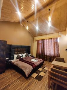a bedroom with a large bed and wooden ceilings at Prāṇa Boutique Stays in Vashisht
