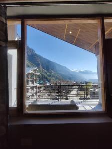 a window with a view of a mountain view at Prāṇa Boutique Stays in Vashisht