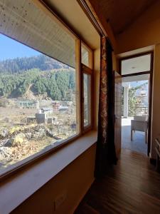 a window in a room with a view at Prāṇa Boutique Stays in Vashisht