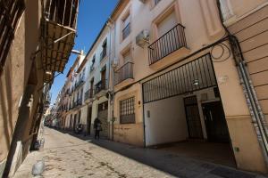 Uma mulher a andar numa rua num beco. em Apartamento San Isidro Centro em Granada