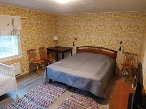 a bedroom with a bed and a table and chairs at Punavilla Cottage in Eura