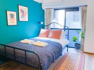 een blauwe slaapkamer met een bed met twee handdoeken erop bij Al Di La 四谷 in Tokyo