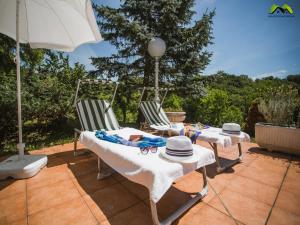 2 sillas, mesa y sombrilla en el patio en Holiday Home Boltar en Varaždin