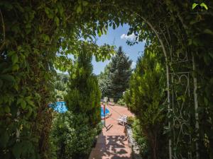 an archway leading to a pool in a garden at Holiday Home Boltar in Varaždin