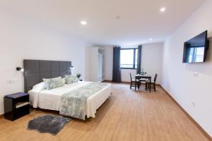 a bedroom with a large bed and a table at Loft Matilde by Grupo Matilde in Las Palmas de Gran Canaria