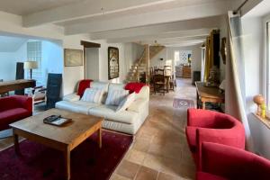 a living room with a white couch and red chairs at Maison de famille près de la mer in Bénodet