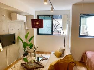 a living room with a couch and a tv at Ken's Place四谷 in Tokyo +33 photos