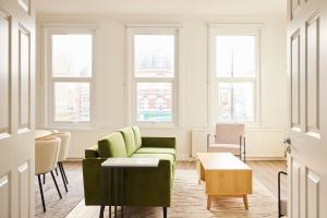 een woonkamer met een groene bank en stoelen bij The Fulham Escape - Alluring 5BDR Flat in Londen