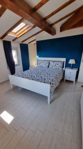 een grote slaapkamer met een bed en een blauwe muur bij Casa Elsa in Torri del Benaco