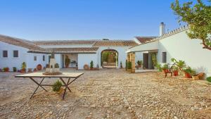 una grande casa bianca con un tavolo in cortile di Casa Rural Viña Romanito Jerez de la Frontera by Ruralidays a Jerez de la Frontera