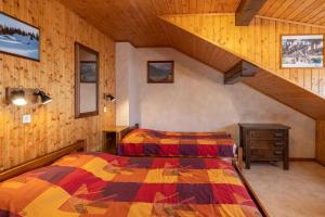 um quarto com uma cama num chalé de madeira em La Rose des Vents N 3 em Châtel