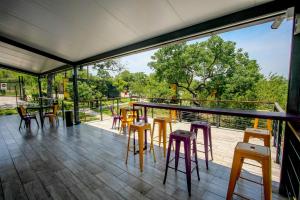 a patio with stools and tables on a deck at SleepOver Kruger Gate in Skukuza