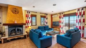 a living room with blue couches and a fireplace at Cortijo Barranco Hondo Íllora by Ruralidays in Illora