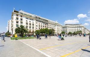 a group of people walking around a plaza in front of a building at Square Elegant Suites in Thessaloniki