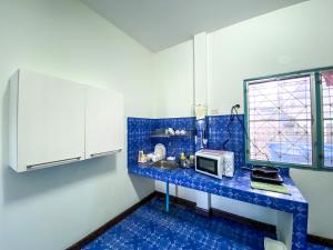 een blauwe en witte keuken met een wastafel en een magnetron bij Karon House 15C in Karon Beach