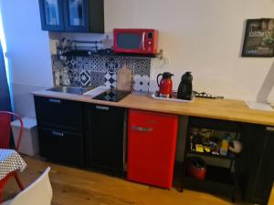 a kitchen with a red refrigerator and a counter at Escapade Amiens in Amiens