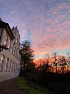 a building with a sunset in the sky at Herrenhaus Hohewarte in Lübeck