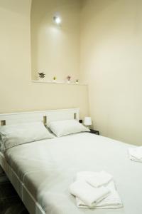 ナポリにあるLa maison de Marieのベッドルーム1室(白いベッド1台、タオル付)
