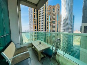 - Balcón con mesa y sillas en un edificio en SKY NEST HOLIDAY HOMES 1 bedroom Apartment dubai marina 2903 en Dubái