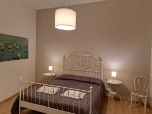 1 dormitorio con 1 cama y 2 mesas en Appartamento La Rampa, en Benevento