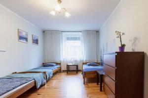 um quarto com três camas e uma cómoda e uma janela em Spękane Skały - Apartament em Miszkowice