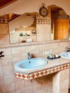 uma casa de banho com 2 lavatórios e um espelho grande em Gemütliche Wohnung mit Ofen und Naturblick em Wildpoldsried
