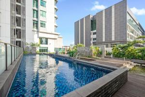 una imagen de una piscina en medio de dos edificios en LAILA by Kozystay Puri Indah, en Yakarta