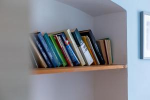 una fila de libros en un estante en una pared en Spękane Skały - Apartament, en Miszkowice