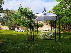 - un kiosque avec une table et des chaises dans la cour dans l'établissement Les Salamandres, chambres d'hôtes près de Chambord, à Montlivault