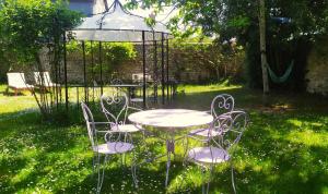 une table, des chaises et un parasol dans l'herbe dans l'établissement Les Salamandres, chambres d'hôtes près de Chambord, à Montlivault