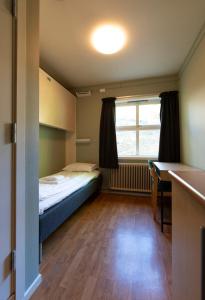 Habitación pequeña con cama y ventana en Kongsberg Hostel-Vandrerhjem, en Kongsberg