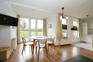 una cucina e una sala da pranzo con tavolo e sedie di Sünnslag Wohnung 026EG a Boltenhagen