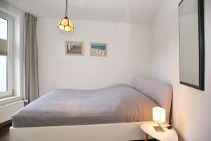 una camera bianca con letto e lampada di Sünnslag Wohnung 026EG a Boltenhagen