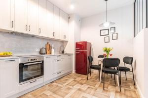 Il comprend une cuisine équipée d'un réfrigérateur rouge et d'une table avec des chaises. dans l'établissement Apartament Active Mercure, à Lublin