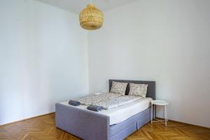 Bett in einem Zimmer mit einer weißen Wand in der Unterkunft Vienna Living Apartments - Müllnergasse in Wien