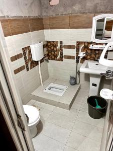 a bathroom with a toilet and a sink at Shelton Royal Hotel in Multan +9 photos