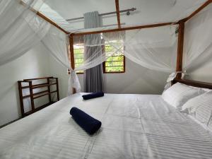 a bedroom with a large white bed with curtains at King CoCo House in Dickwella +33 photos