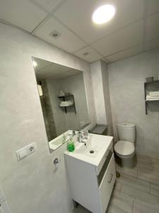 W łazience znajduje się umywalka, toaleta i lustro. w obiekcie Apartamento Centro Fuengirola w mieście Fuengirola
