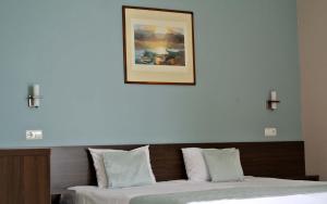 a bedroom with two beds and a picture on the wall at Valeo Hotel in Balchik
